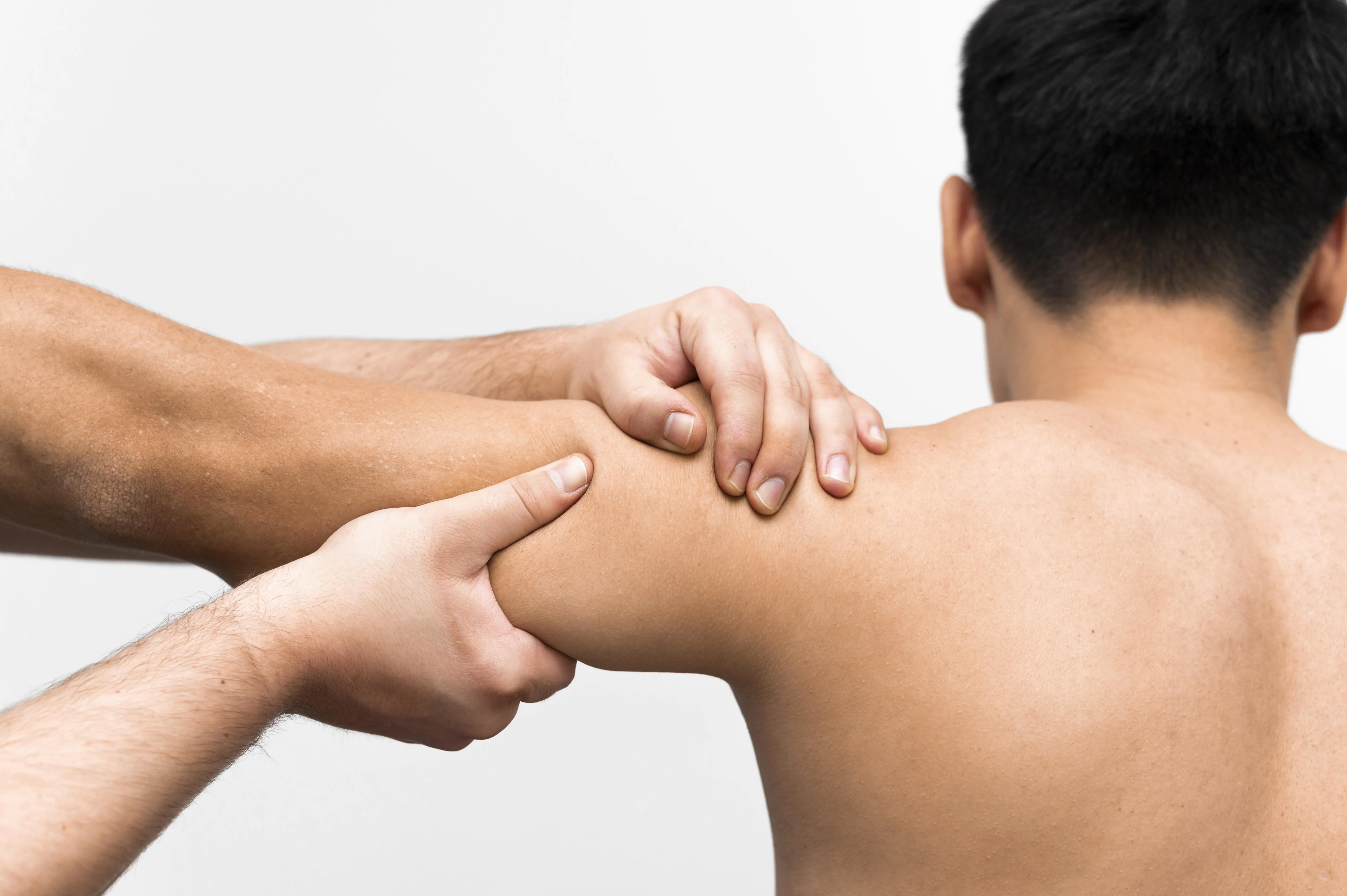 Man får kinesiologibehandling på axel